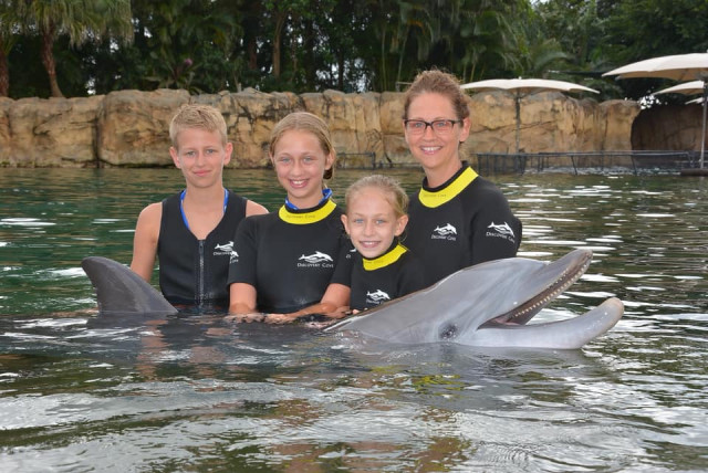 Shae and family with dolphin at Discovery Cove