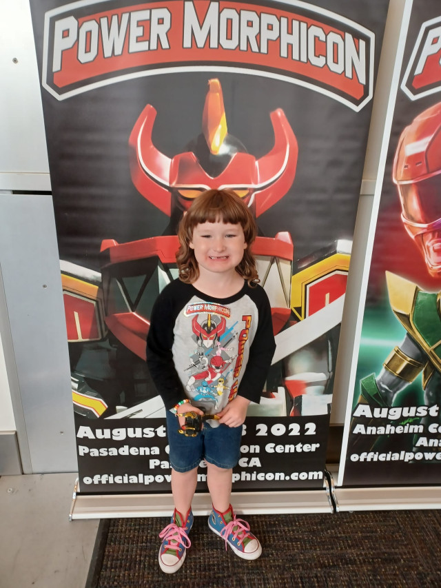 Kyler in front of Power Morphicon Sign