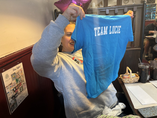 Lucie Mom Holding WCH Shirt at Presentation